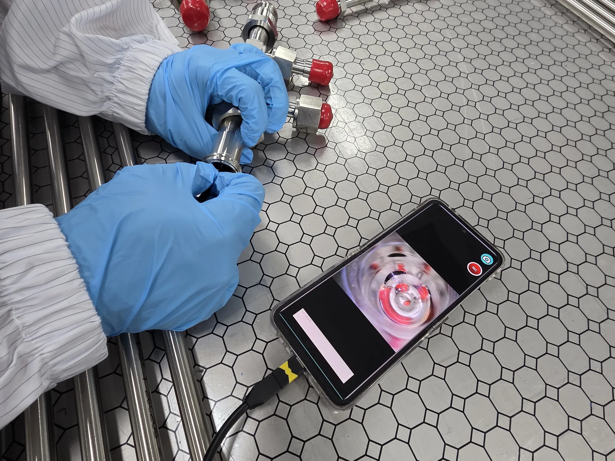A borescope inserted into piping while its internal view is checked on a display
