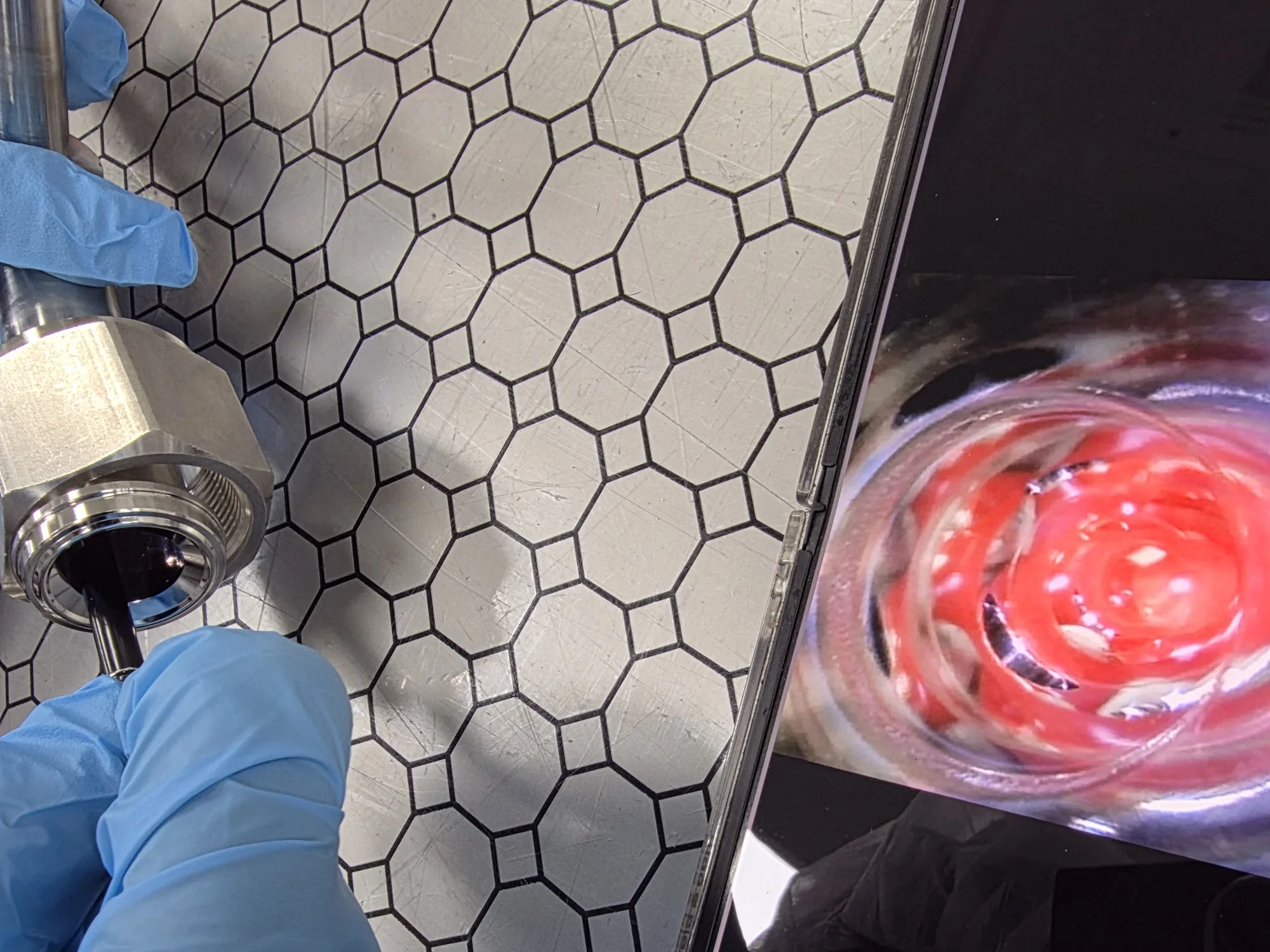 A close view of a borescope entering a pipe while its internal image is checked on a display